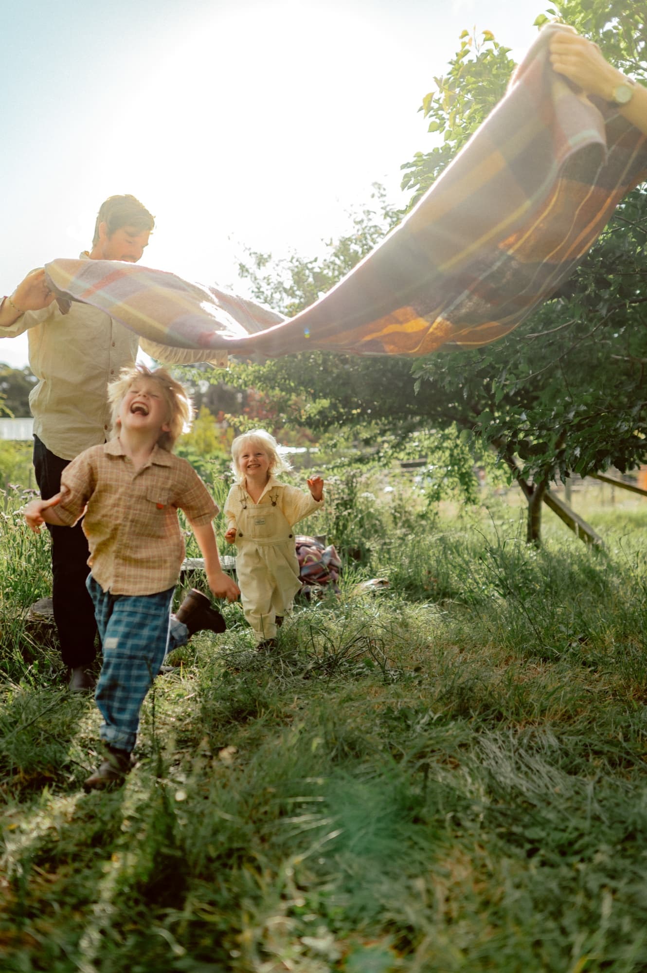The family running back to their picnic blanket in the paddock.
